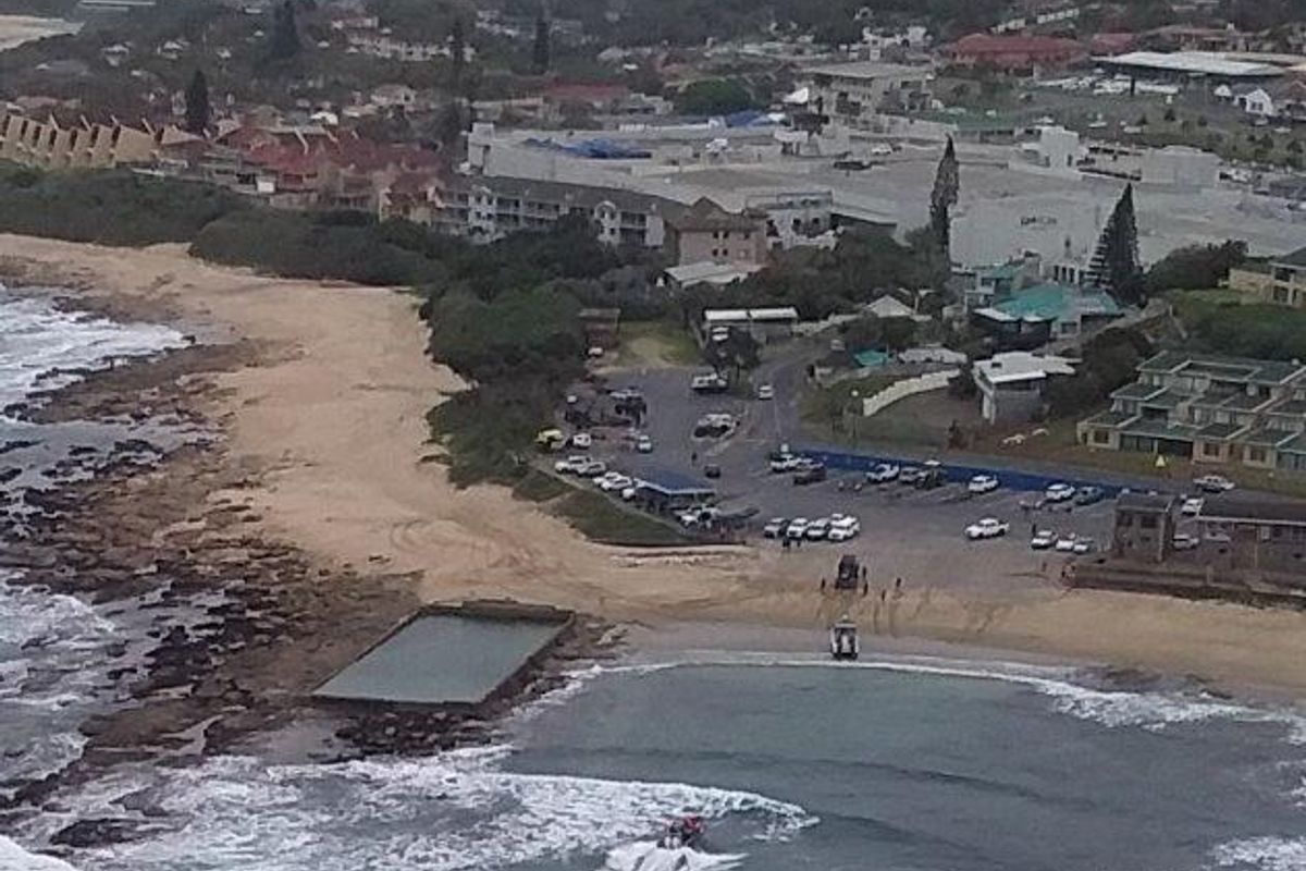 Aerial view of the coastal commercial property location, featuring proximity to the beach, tidal pool, and surrounding urban infrastructure.