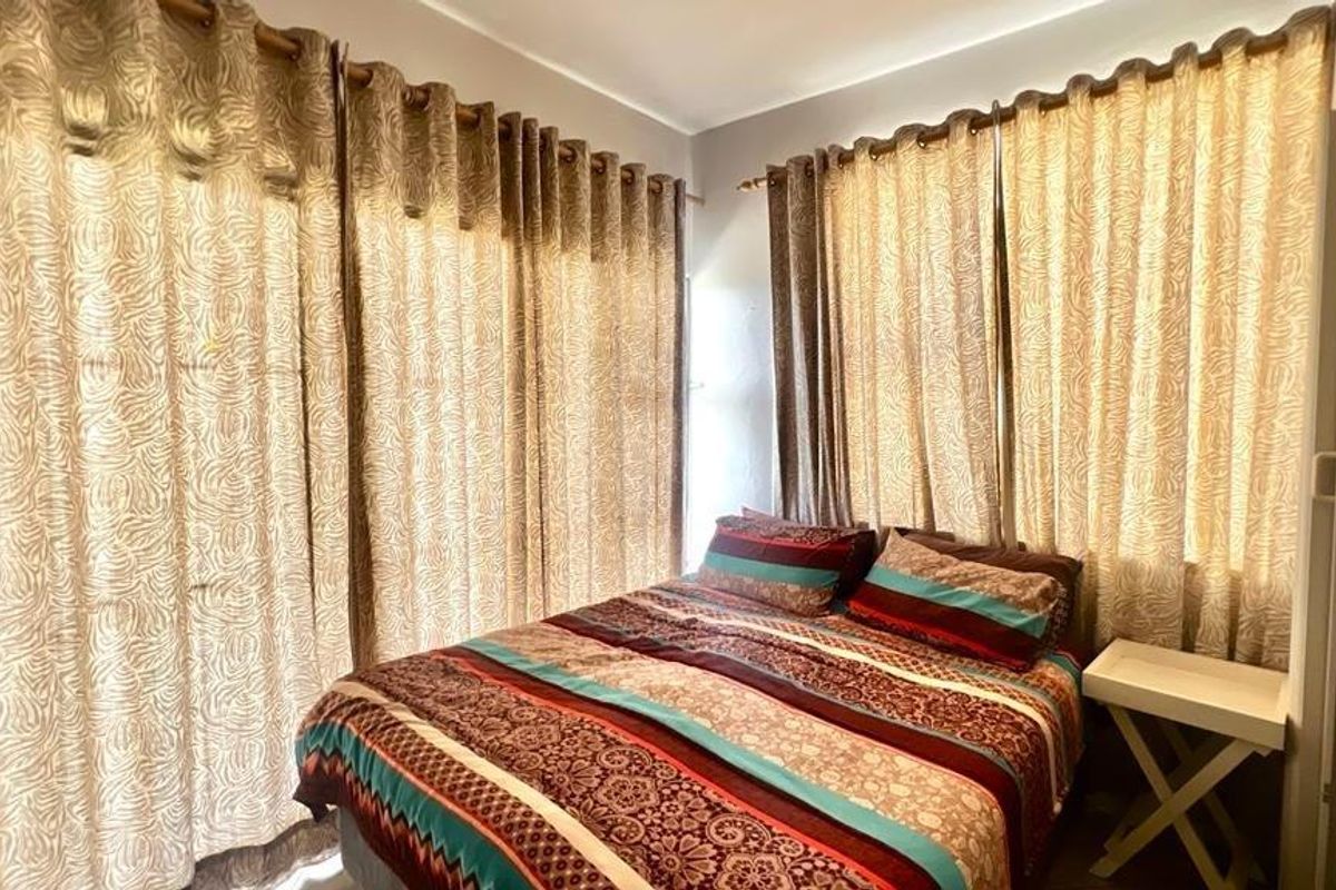 A cozy bedroom featuring floor-to-ceiling curtains that provide ample natural light control and privacy.