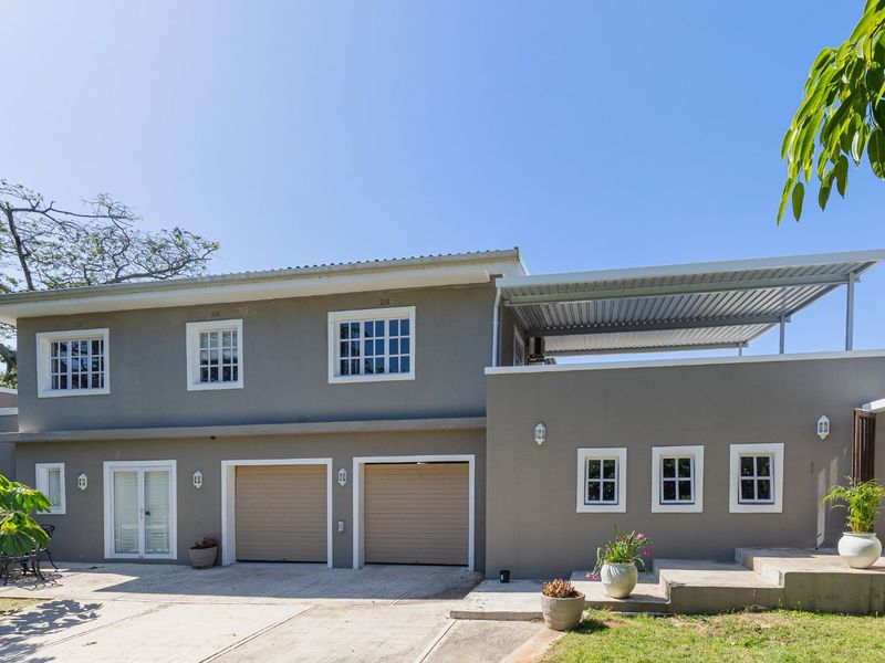 Front elevation of a two-story residence featuring a double garage, covered upper-level patio, and well-maintained exterior finishes.