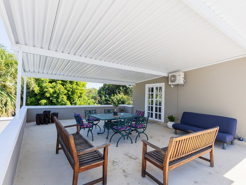 Spacious covered patio featuring a corrugated metal roof, concrete flooring, and direct access to the interior via french doors.