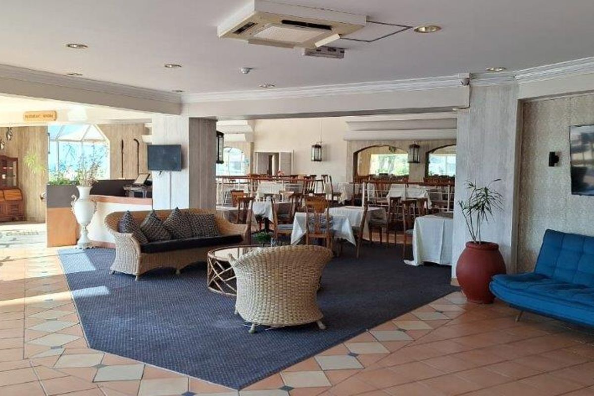 Spacious open-plan living and dining area featuring tiled flooring, recessed ceiling lighting, and integrated air conditioning units.