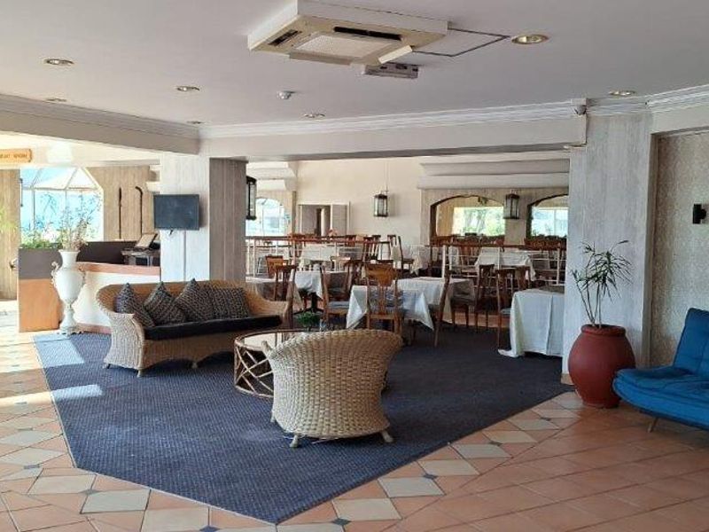 Spacious open-plan living and dining area featuring tiled flooring, recessed ceiling lighting, and integrated air conditioning units.