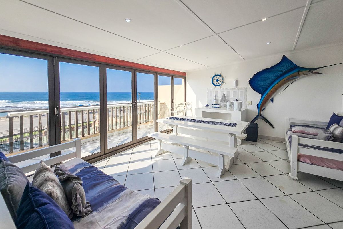 Spacious sunroom featuring large glass sliding doors with panoramic ocean views, tiled flooring, and recessed ceiling lighting.