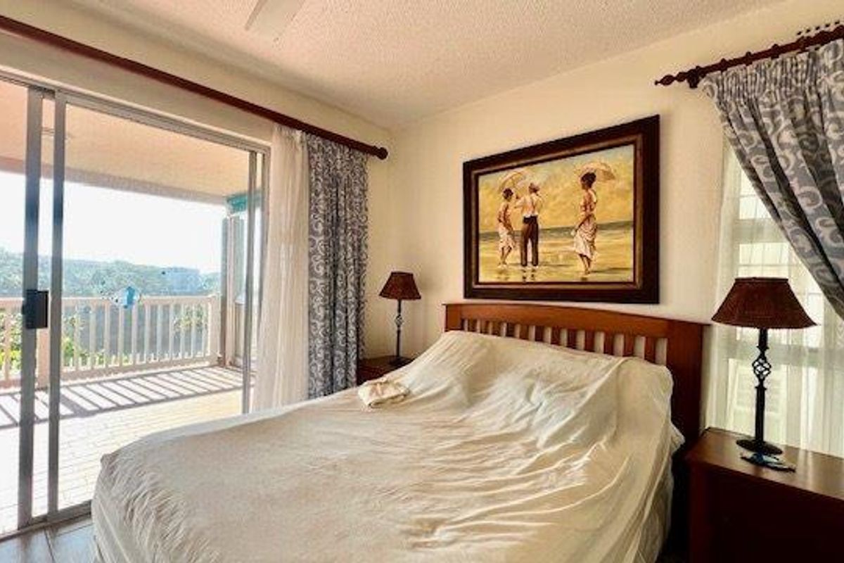 A bedroom featuring tiled flooring, a ceiling fan, and a sliding glass door providing direct access to an outdoor balcony.