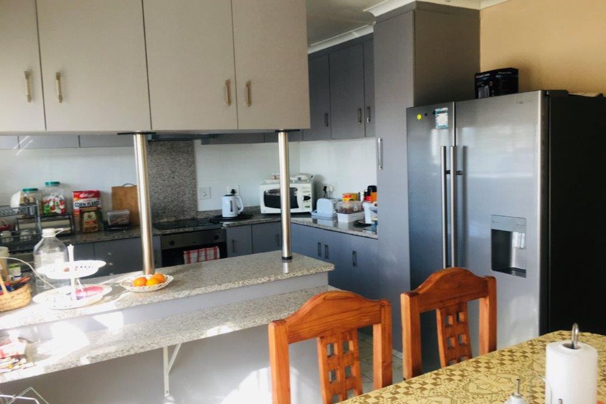 A functional kitchen featuring granite countertops, ample built-in cabinetry, a breakfast bar, and integrated appliances, offering a practical layout for daily cooking.