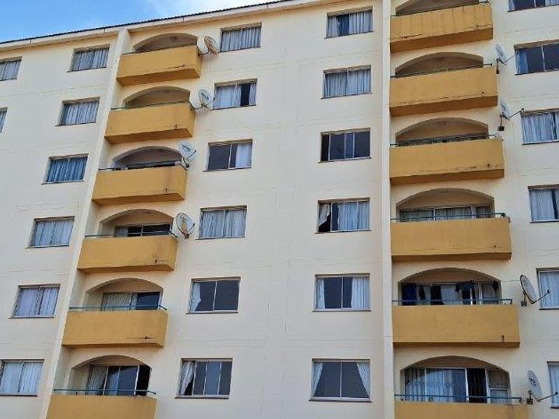 Exterior view of a multi-story apartment building featuring repetitive balconies and window configurations.