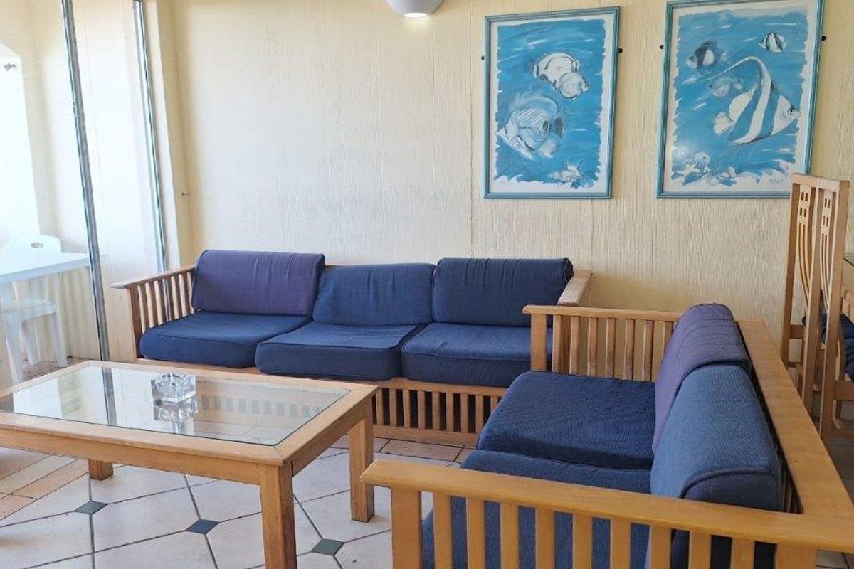 A living room area featuring tiled flooring and sliding glass doors leading to an outdoor space, providing a functional and bright living environment.