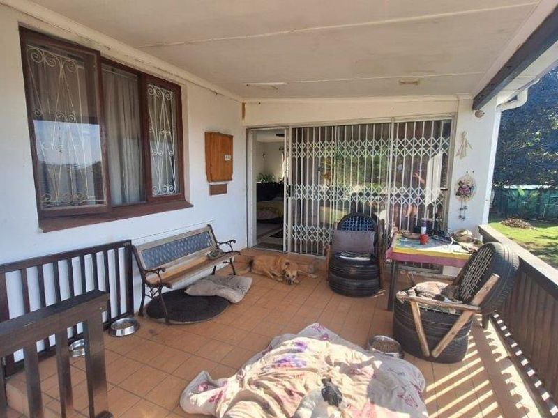A covered outdoor patio area featuring tiled flooring, security gates, and direct access to the interior living space.