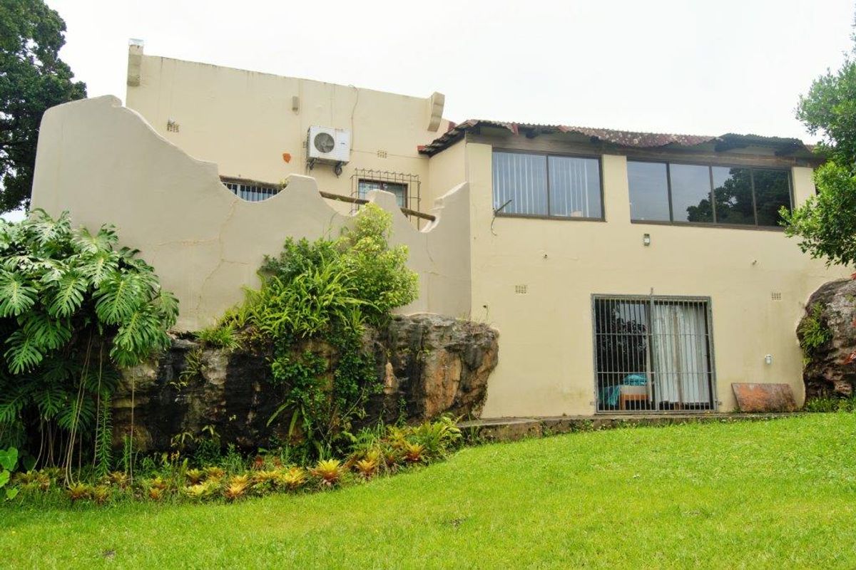 Rear view of the farm property featuring a natural rock foundation, sliding glass doors with security bars, and an exterior air conditioning unit.