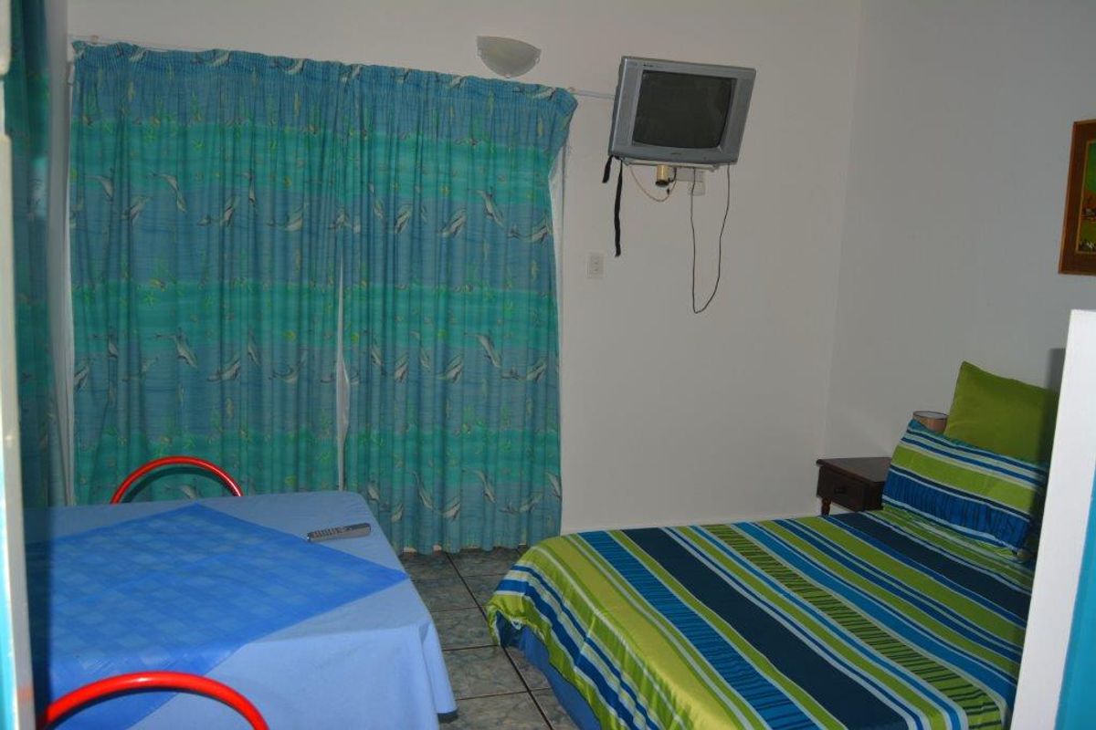 A bedroom featuring tiled flooring and a wall-mounted television unit, providing a functional sleeping space within the commercial property.