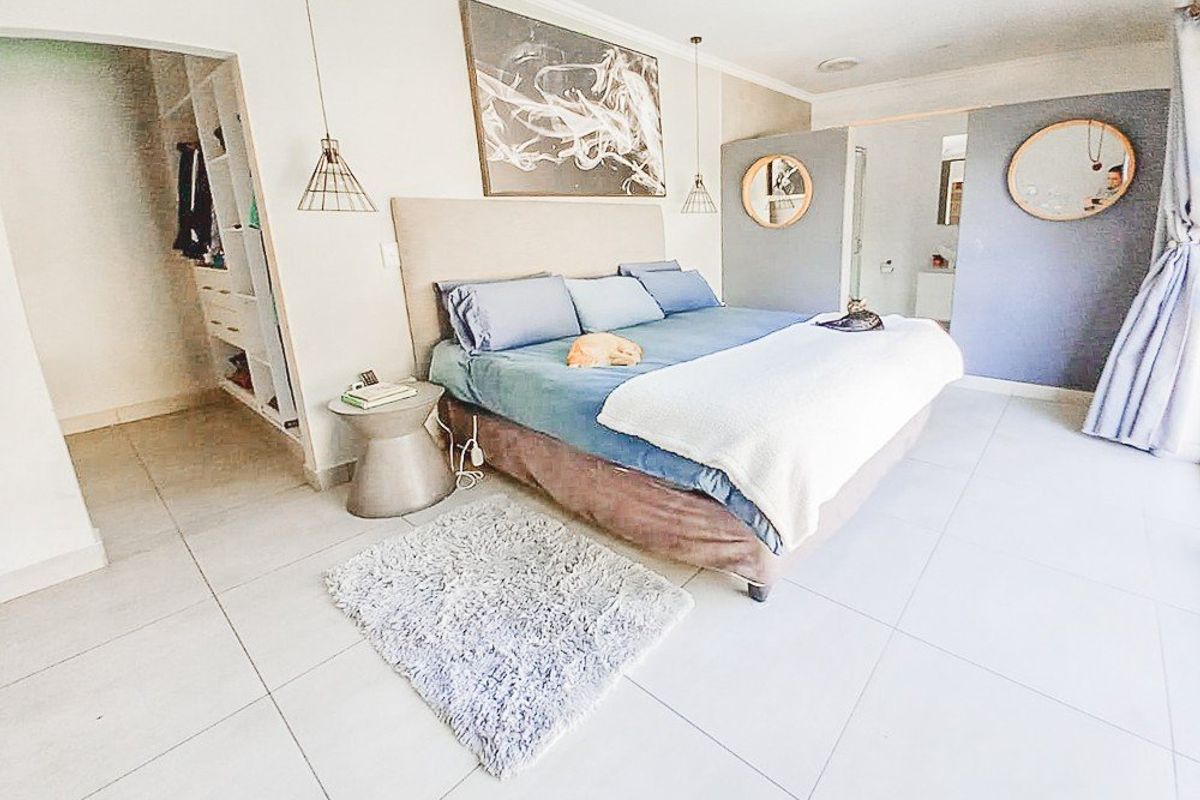 Spacious bedroom featuring tiled flooring, integrated walk-in closet, and an en-suite bathroom with modern finishes.