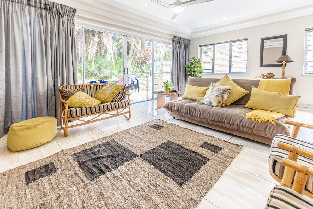 A bright and spacious living room featuring large sliding glass doors that provide seamless access to the outdoor patio area.