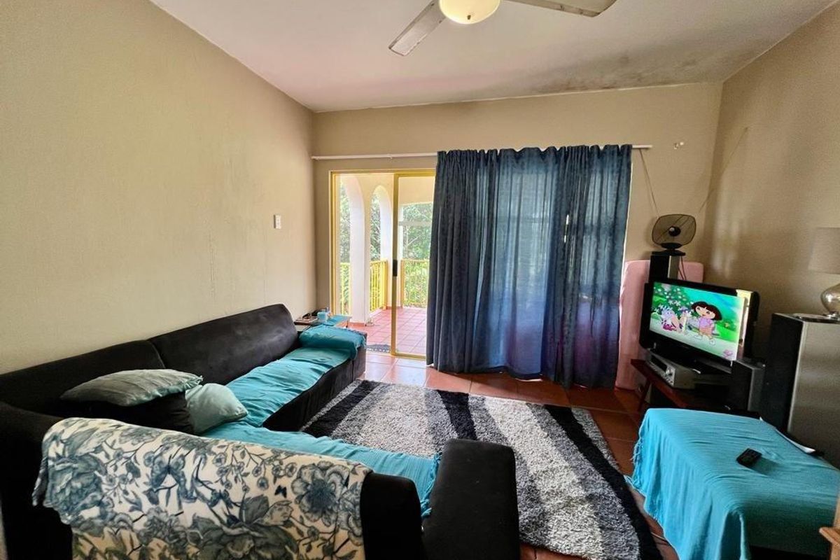Living room featuring tiled flooring, a ceiling fan, and sliding glass door access to an outdoor balcony area.