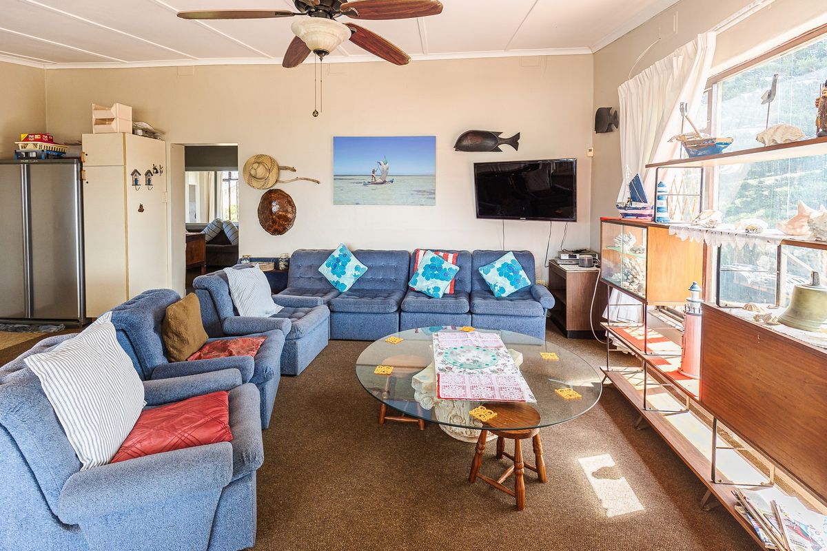 A spacious living room featuring a ceiling fan and large window, offering a comfortable area for relaxation and family gatherings.