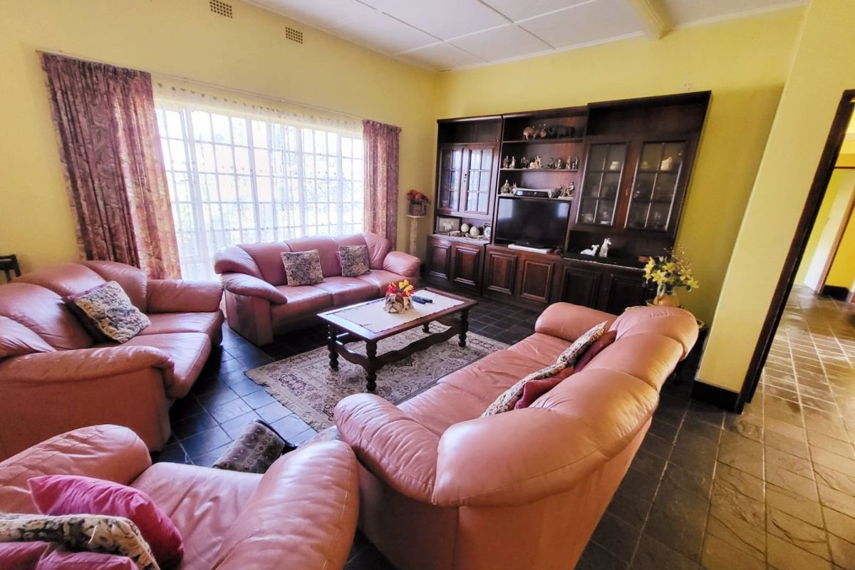 Spacious living room featuring dark slate tile flooring, built-in wooden cabinetry, and large windows that provide ample natural light.