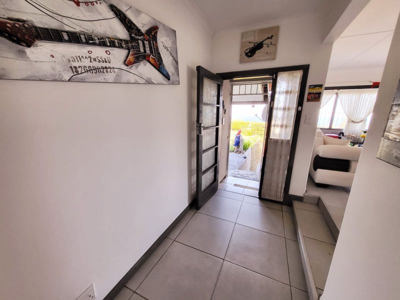 Entrance foyer featuring tiled flooring and a timber-framed glass door leading to the exterior.
