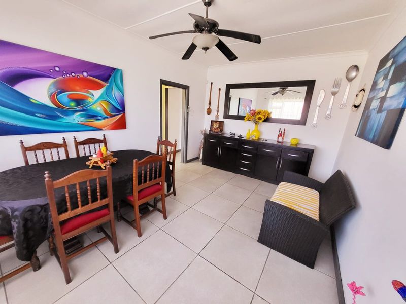 A dining room featuring tiled flooring and a ceiling fan, providing a functional space for meals and gatherings.