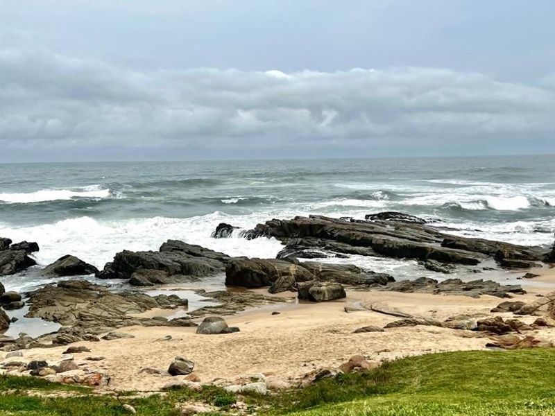 A scenic view of the rocky coastline and ocean waves, showcasing the natural landscape adjacent to the property.