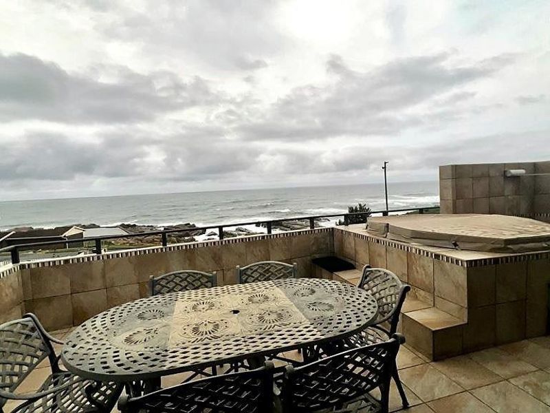 A spacious balcony featuring tiled flooring, a built-in spa bath, and panoramic ocean views, perfect for outdoor relaxation and entertainment.