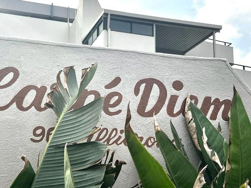 Exterior view of the Carpe Diem apartment complex entrance, featuring modern architectural lines and building signage.