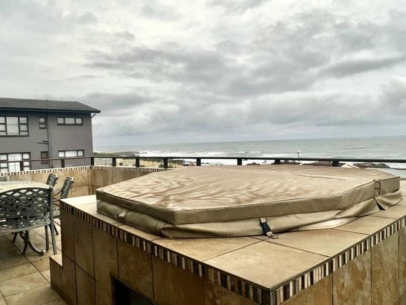 Spacious balcony featuring a built-in tiled spa pool and panoramic ocean views, perfect for outdoor relaxation and entertaining.