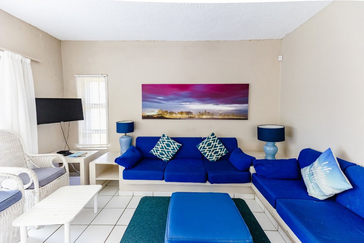 A living room featuring tiled flooring and a neutral wall finish, providing a functional space for relaxation.