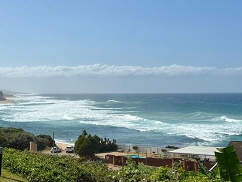 A scenic elevated view overlooking the coastline, ocean waves, and surrounding landscape.