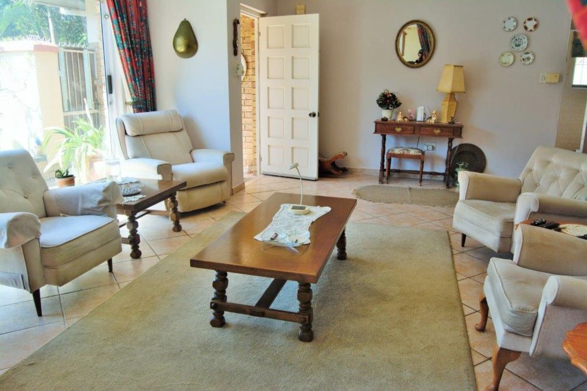 A spacious living room featuring tiled flooring and a sliding glass door providing access to the outdoor area.