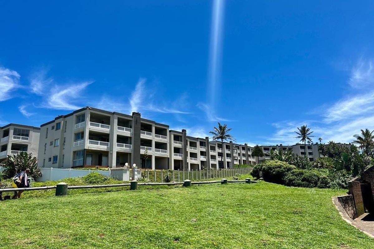 Exterior view of a multi-story apartment complex featuring private balconies and landscaped grounds.