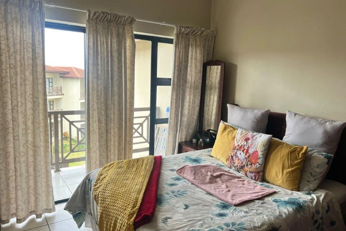 A bedroom featuring tiled flooring and direct access to a private balcony through sliding glass doors, providing natural light and outdoor connectivity.