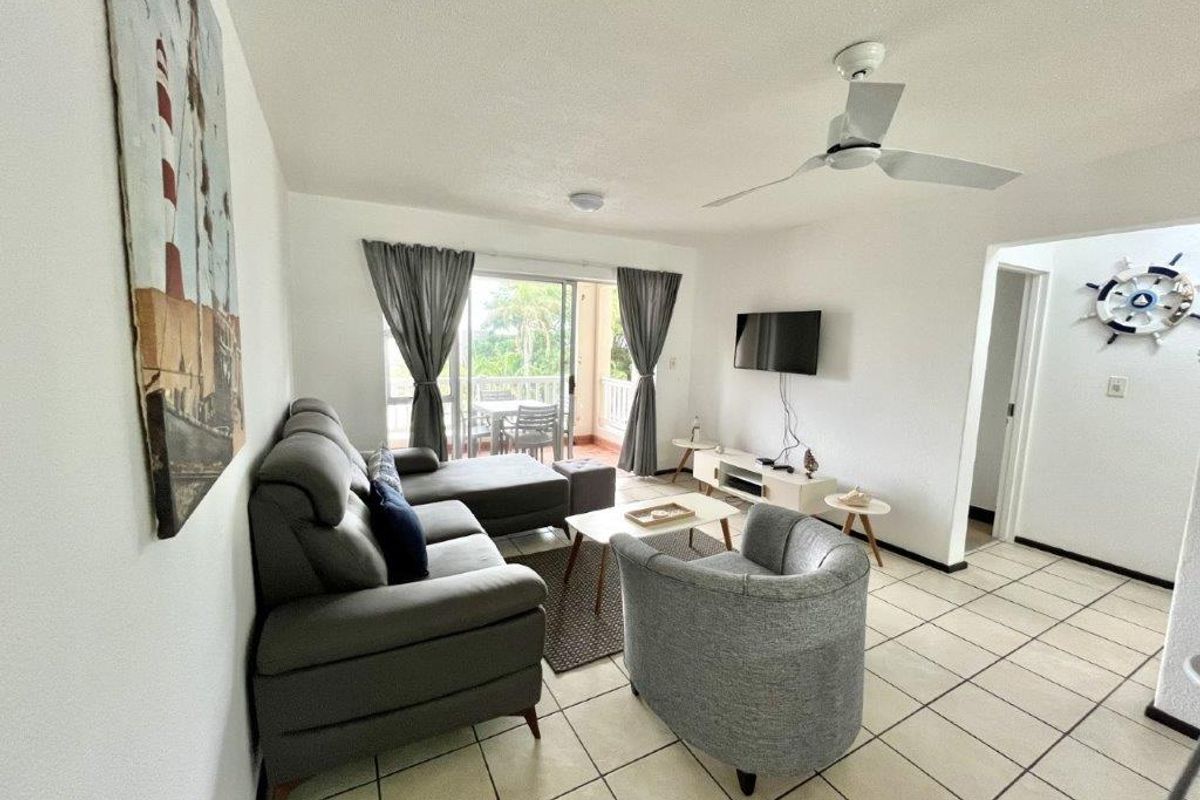 A bright living room featuring ceramic tile flooring, a ceiling fan, and a sliding glass door providing access to an outdoor balcony area.