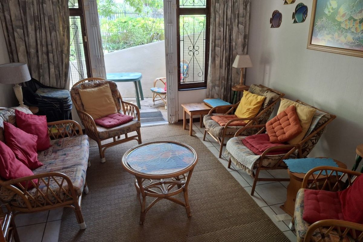 A living room featuring tiled flooring and sliding doors that provide direct access to an outdoor patio area.