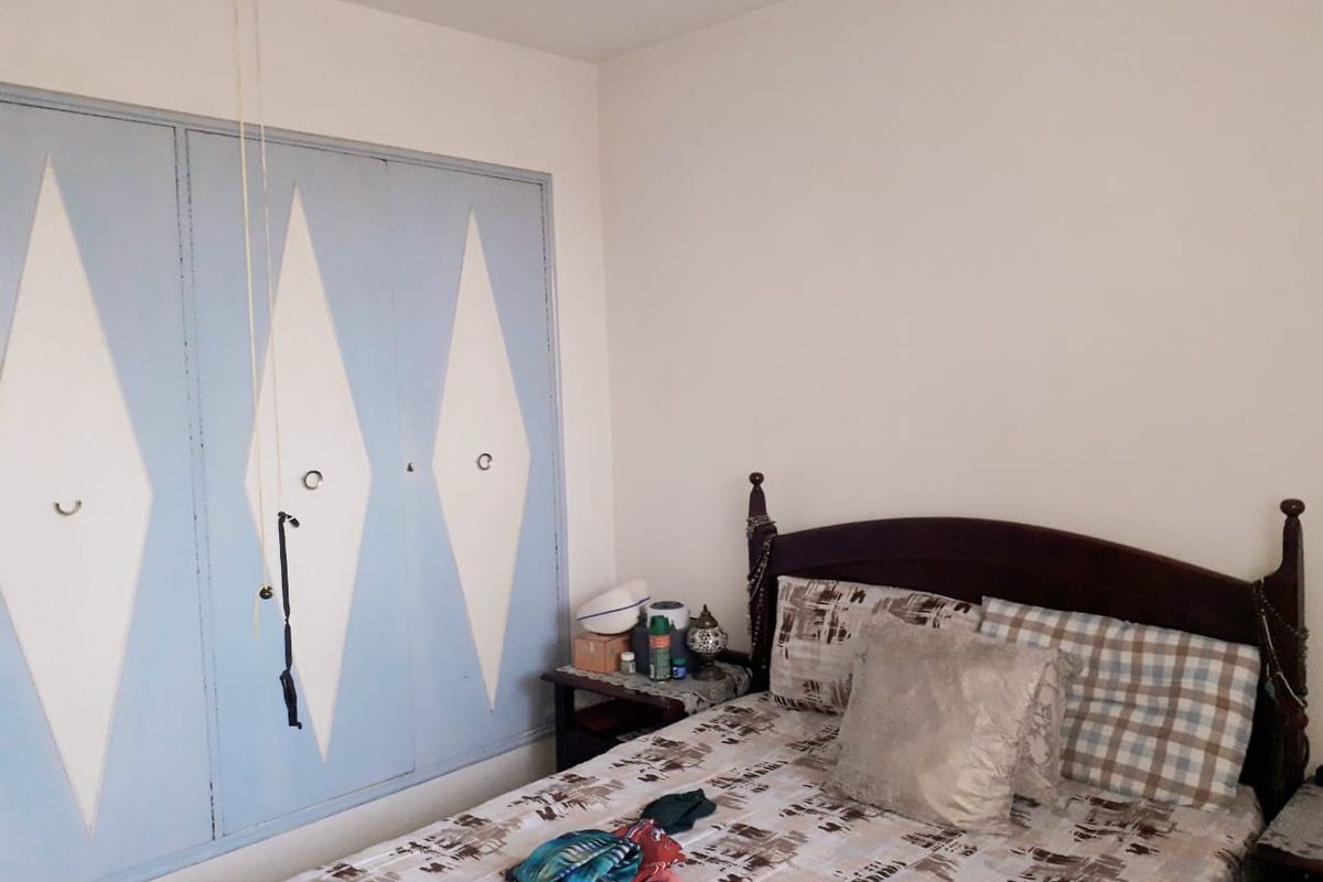 A bedroom featuring a built-in wardrobe with decorative diamond-patterned doors.