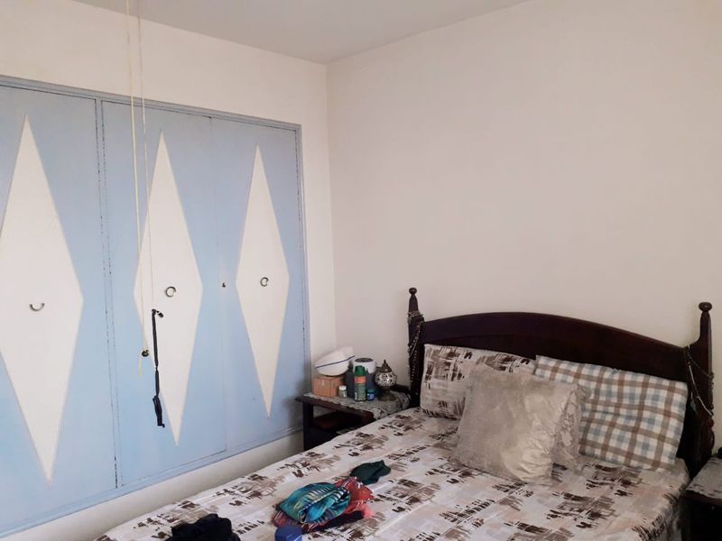 A bedroom featuring a built-in wardrobe with decorative diamond-patterned doors.