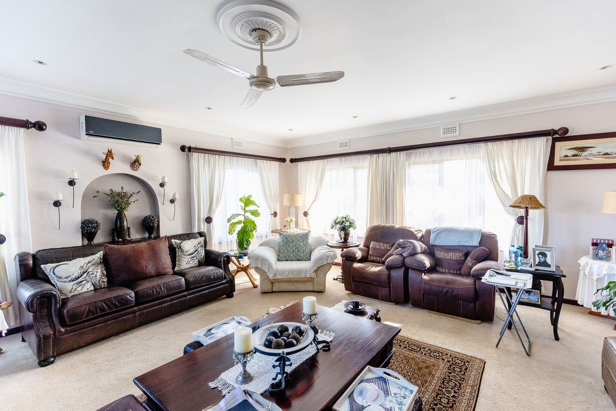Spacious living room featuring a ceiling fan, decorative ceiling rose, recessed lighting, and a built-in arched wall niche.