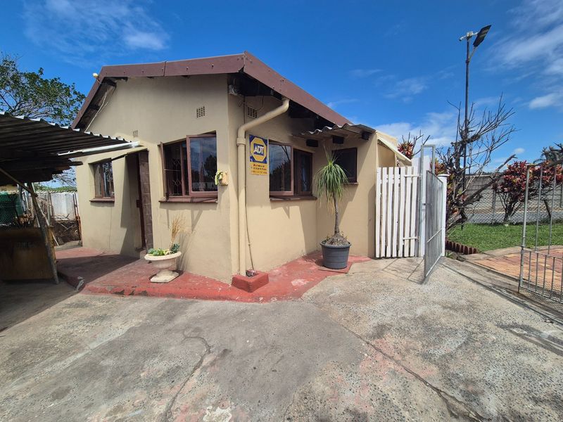 Front exterior view of a single-story house featuring a concrete driveway, security gate, and security bars on the windows.