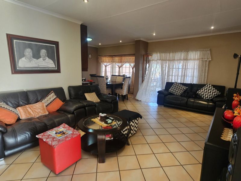 Spacious open-plan living and dining area featuring tiled flooring, recessed lighting, and large sliding doors providing access to the outdoor space.