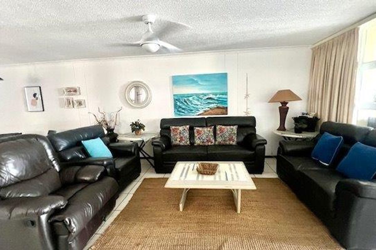 A spacious living room featuring tiled flooring and a ceiling fan, offering a comfortable and functional layout for relaxation.