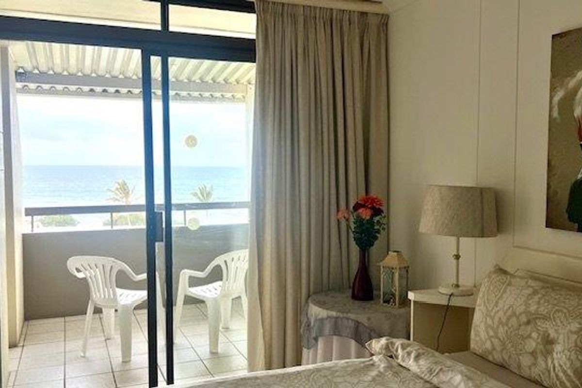 Bedroom featuring a sliding glass door that opens onto a private balcony with ocean views.