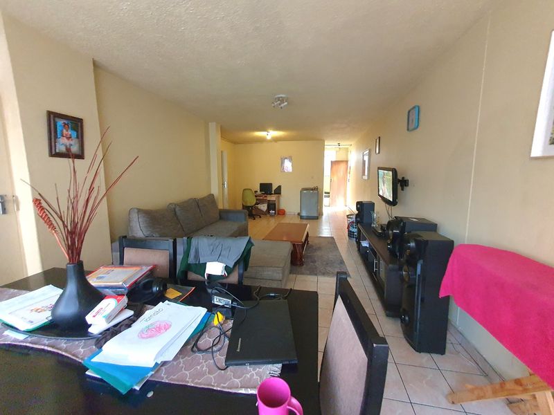 Open-plan living and dining area featuring tiled flooring and neutral wall finishes, providing a functional space for daily living.
