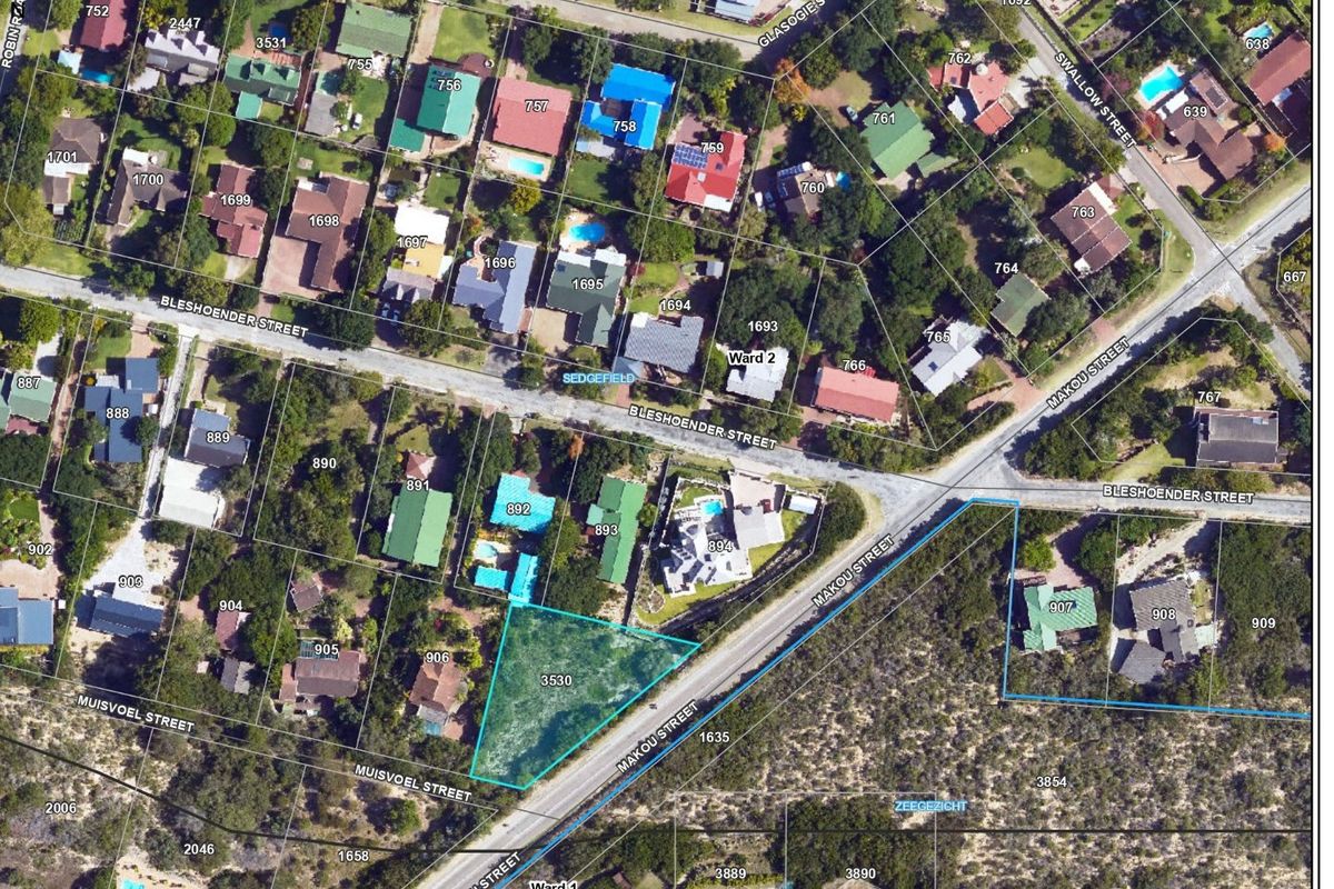 Aerial view of a vacant residential plot highlighted in blue, situated in a developed neighborhood with street access.