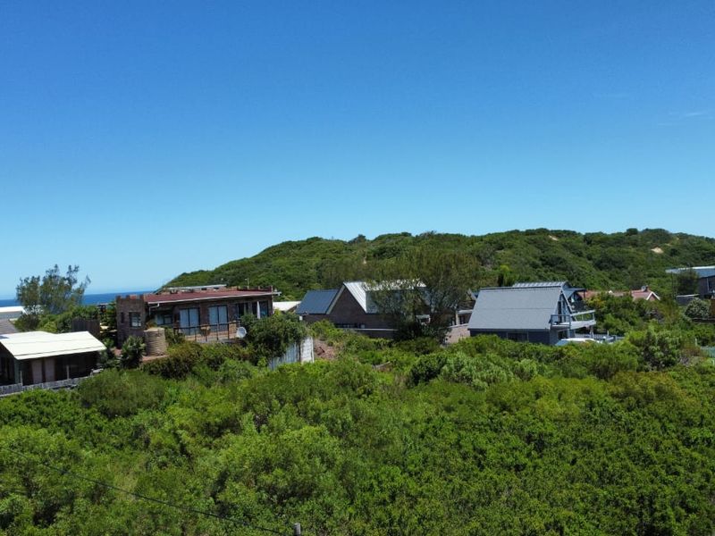 An elevated view of the surrounding residential neighborhood and coastal landscape, showcasing the local environment and nearby properties.