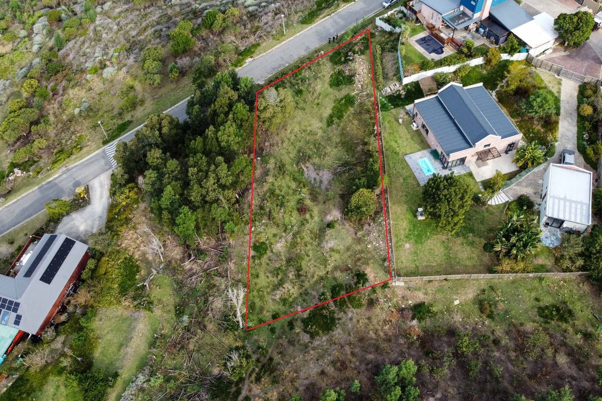 An aerial view of a vacant residential plot of land, clearly outlined in red, situated within a developed neighborhood.