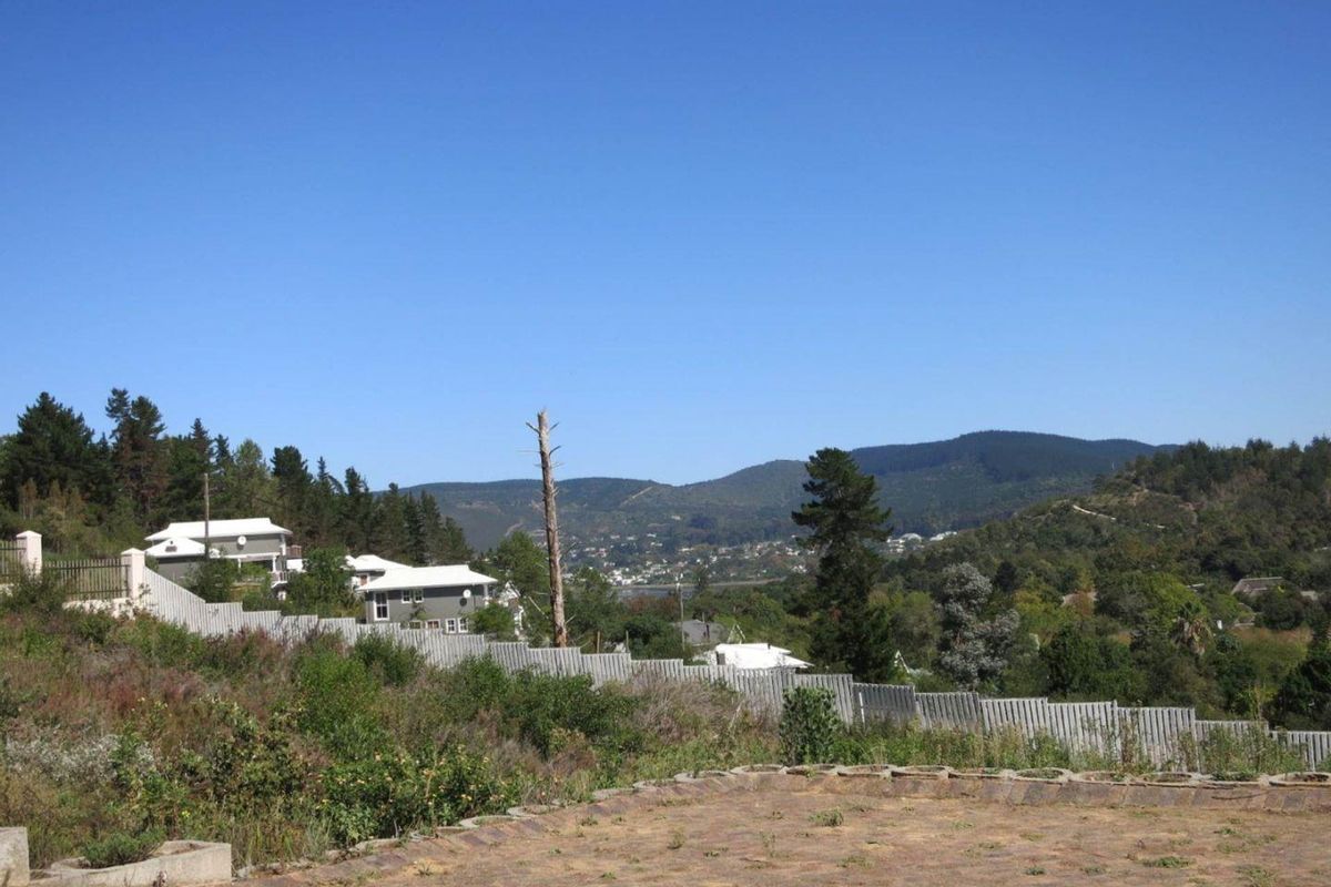 Elevated view overlooking the surrounding landscape, hills, and neighboring residential properties, featuring a clear horizon and natural vegetation.