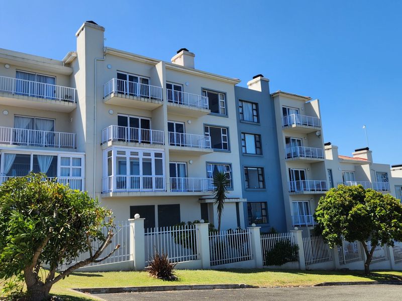 A multi-story apartment complex featuring private balconies with metal railings, sliding glass doors, and a well-maintained exterior facade.