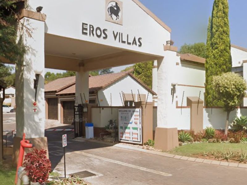 The main entrance to Eros Villas, featuring a secure gated access point with paved driveway and well-maintained landscaping.