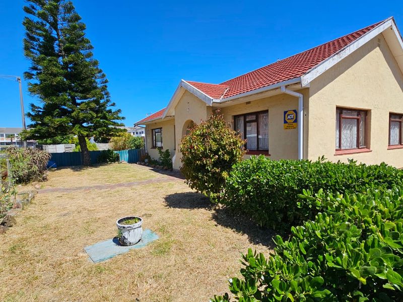 Front view of a residential property featuring a tiled roof, security bars on windows, and a front garden area.
