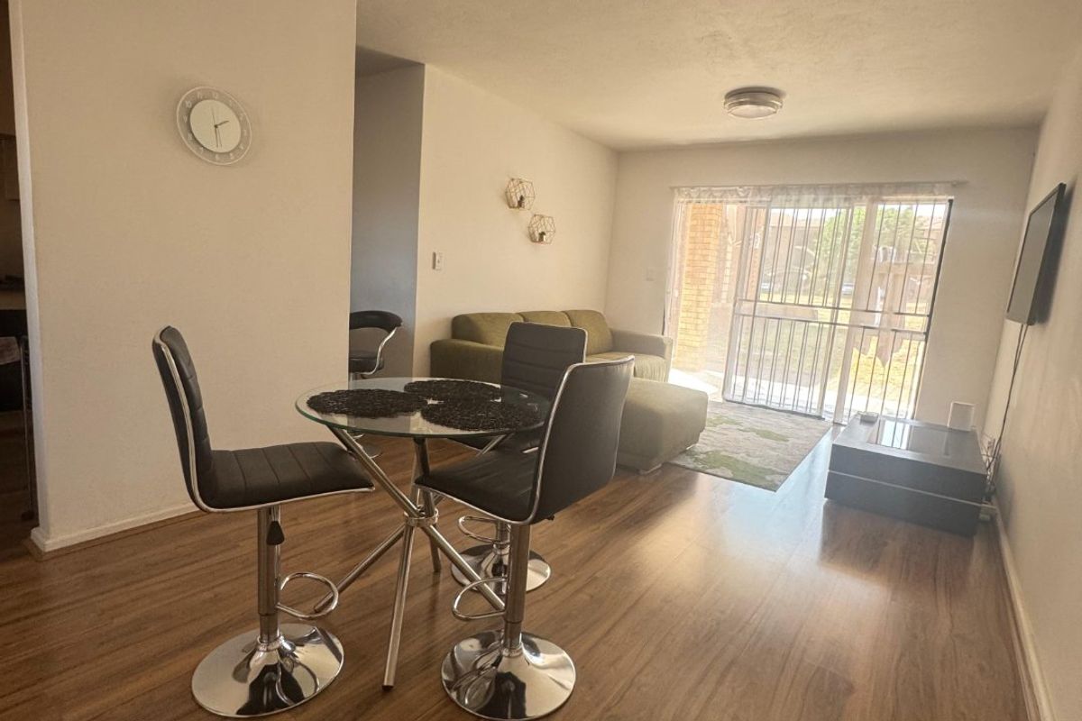 Open plan living and dining area featuring laminate flooring and a sliding glass door providing access to the exterior.