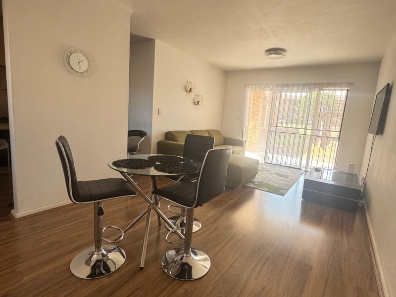 Open plan living and dining area featuring laminate flooring and a sliding glass door providing access to the exterior.