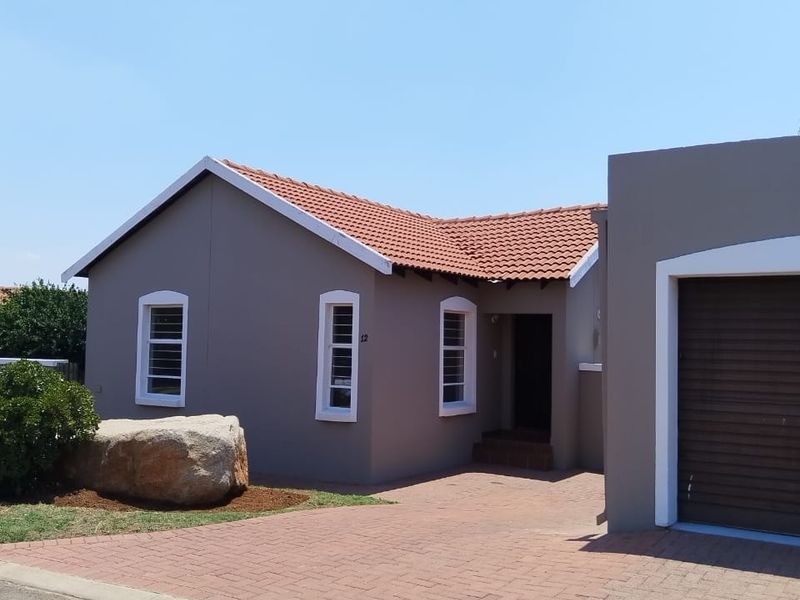 Front elevation of a single-story house featuring a paved driveway, integrated garage, and tiled roof.